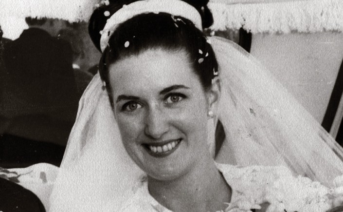 A woman in a wedding dress smiling at the camera